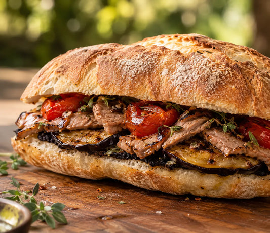 Panino rustico con crema di aglio nero, melanzane e pomodorini alla griglia